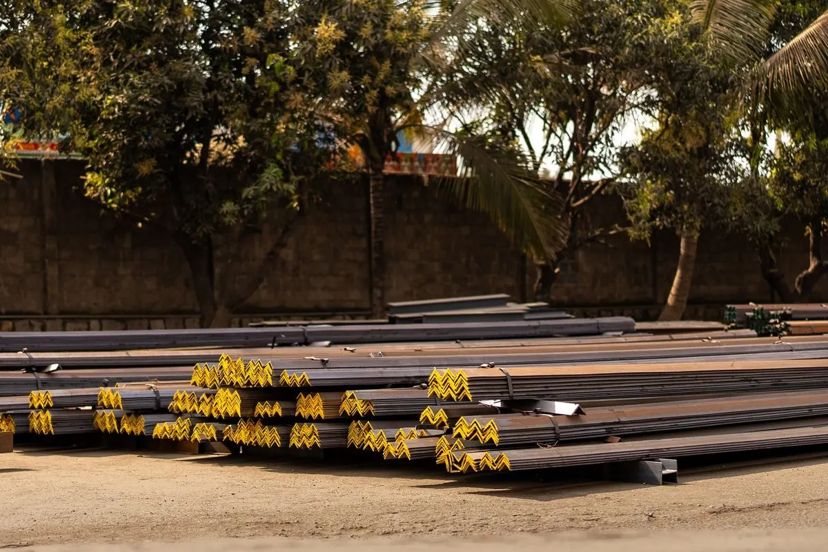 Stacked angle steel with yellow markings in an outdoor yard