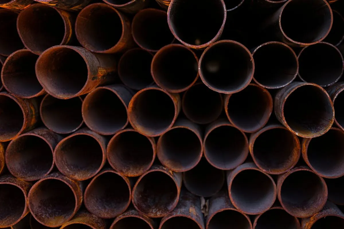 Stack of round rusty steel pipes seen end-on