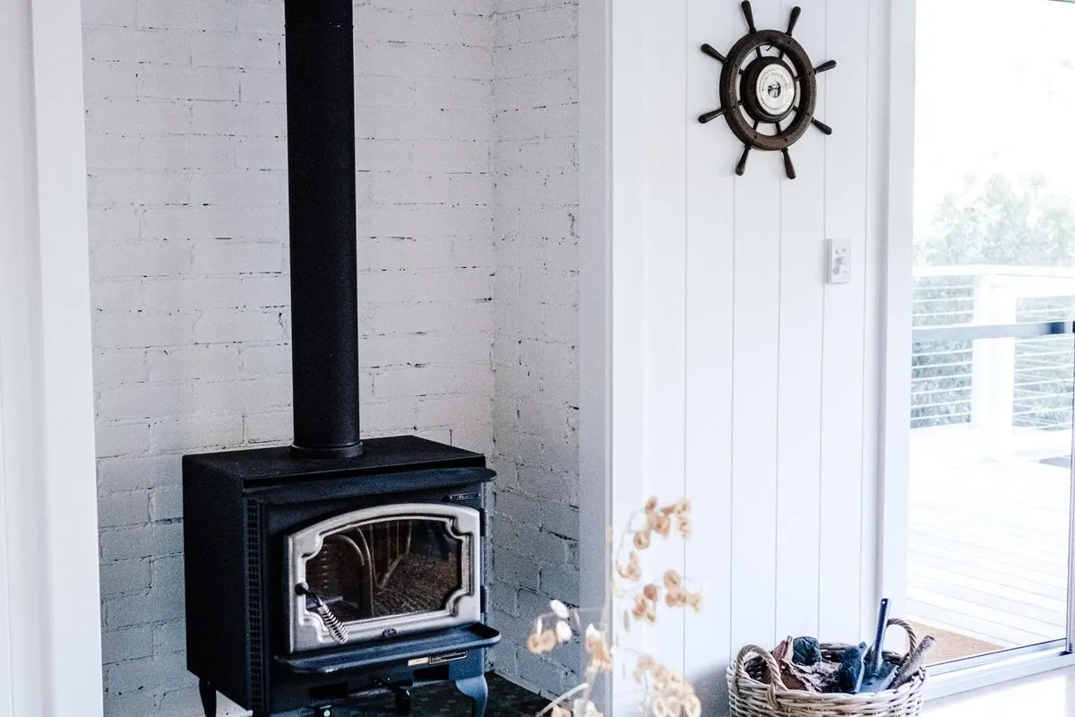 Black wood-burning stove with a flue pipe in a room