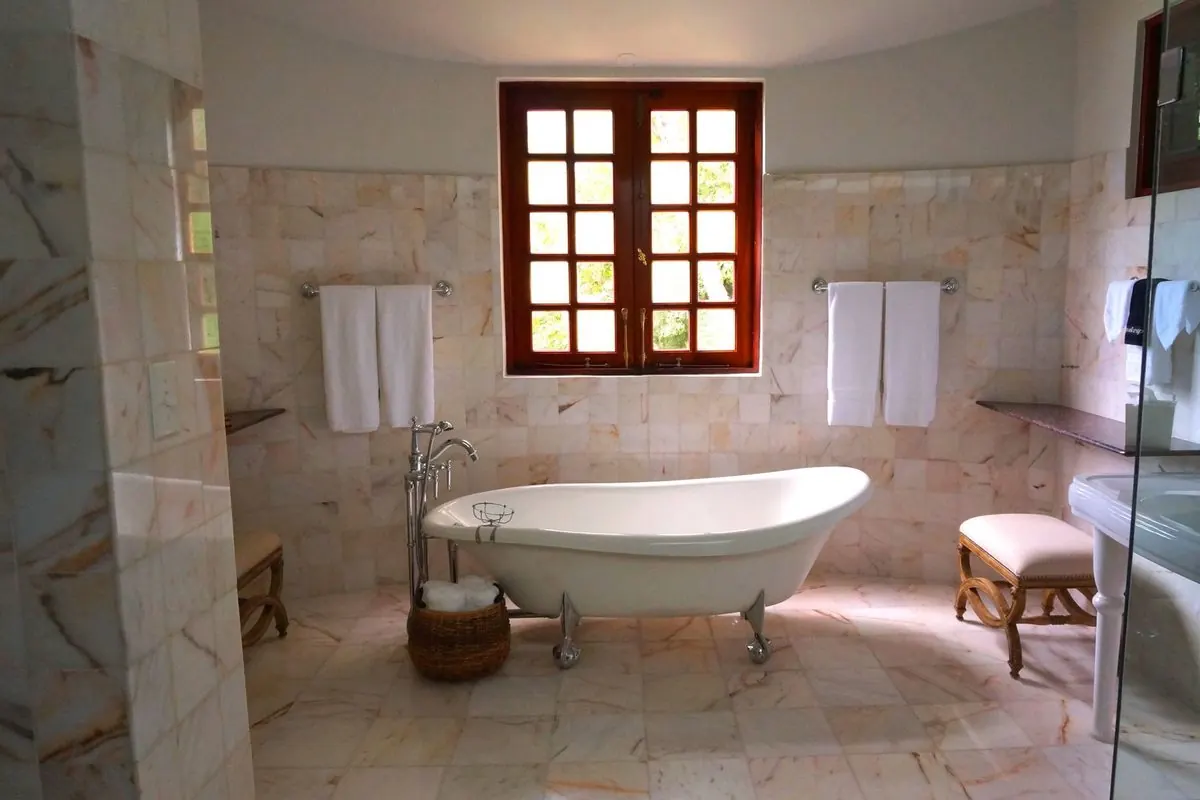 Clawfoot bathtub in a stone-tiled bathroom