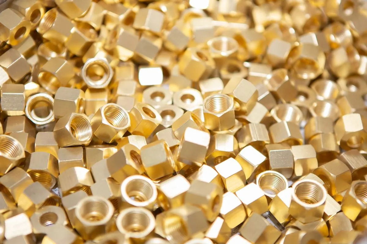 Pile of golden brass nuts and threaded parts