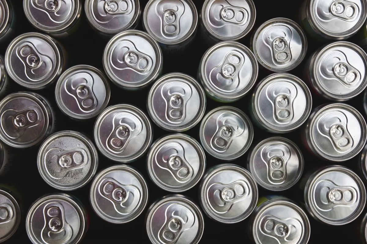 Many aluminium drink cans seen from above, with pull-tab lids