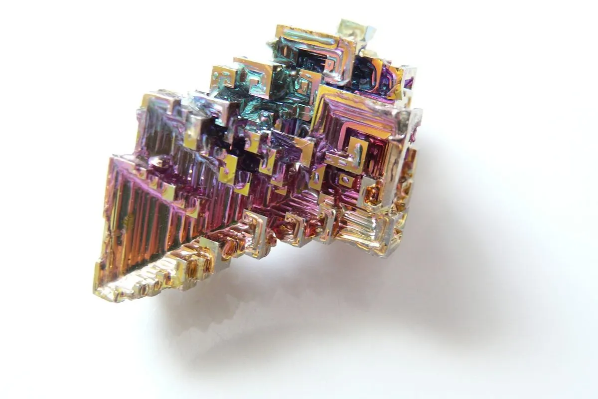 Rainbow-coloured bismuth crystal on a white background