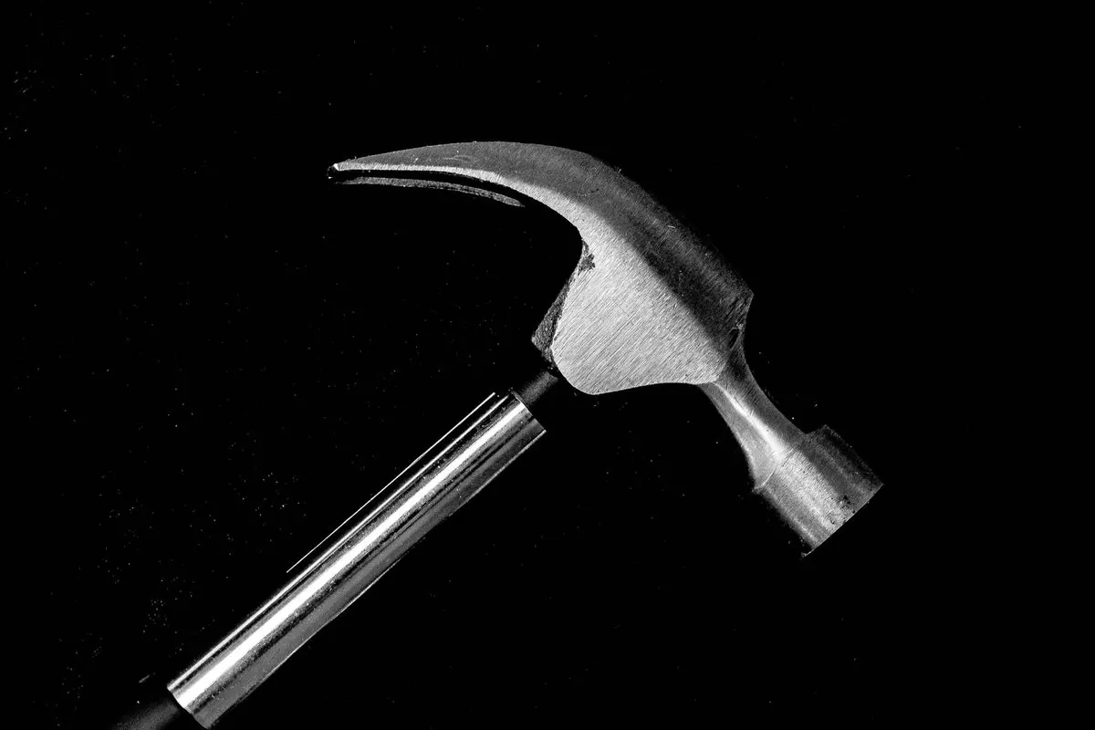 Claw hammer with metal handle on a black background