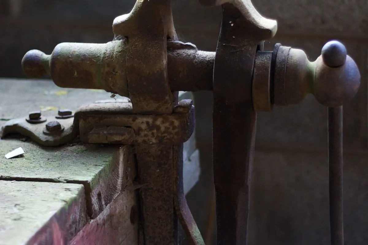 Old bench vise mounted on a wooden workbench