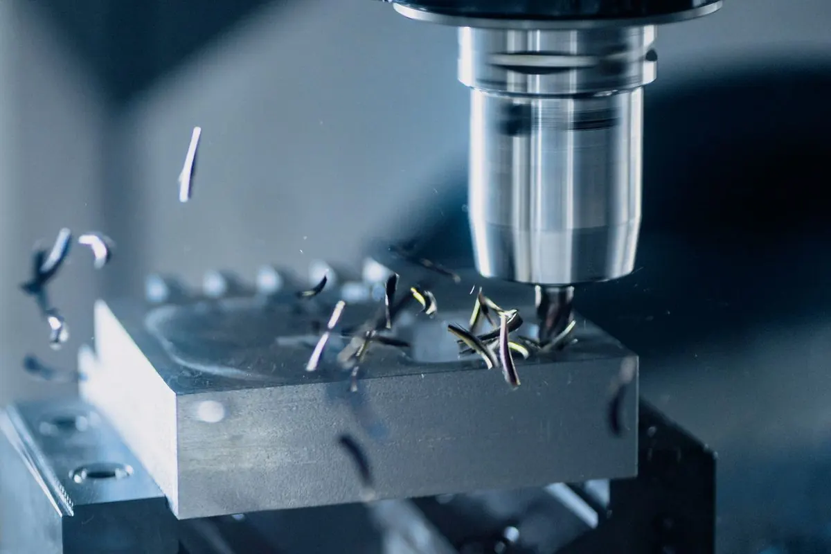 Milling cutter machining a metal block on a milling machine