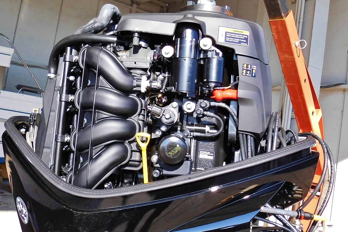 Outboard boat engine with the cover open showing the cylinders inside