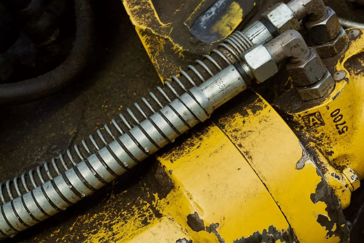 Yellow hydraulic cylinder with hoses