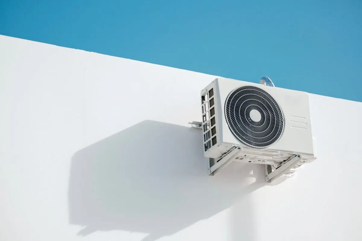 Outdoor air conditioner unit mounted on a white wall