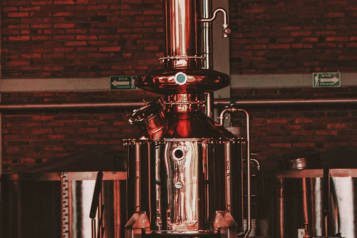 Copper distillation column inside a brick hall