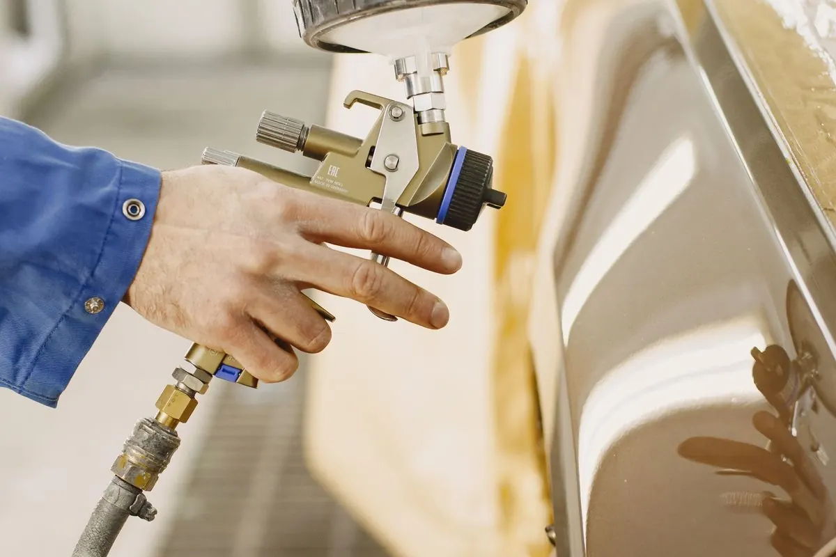 Handheld paint spray gun with a paint cup