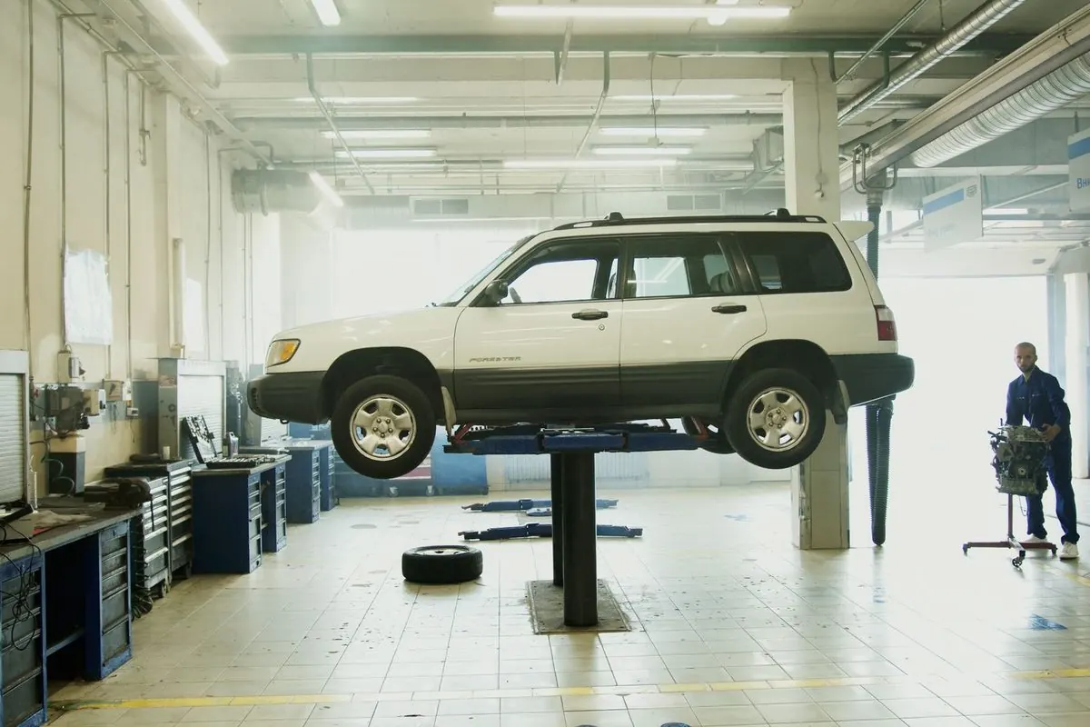 Car raised on a two-post lift in a garage