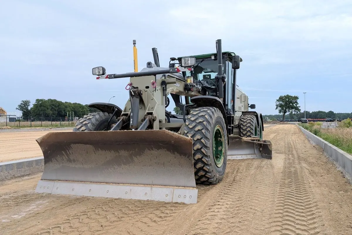 Motor grader levelling a road surface