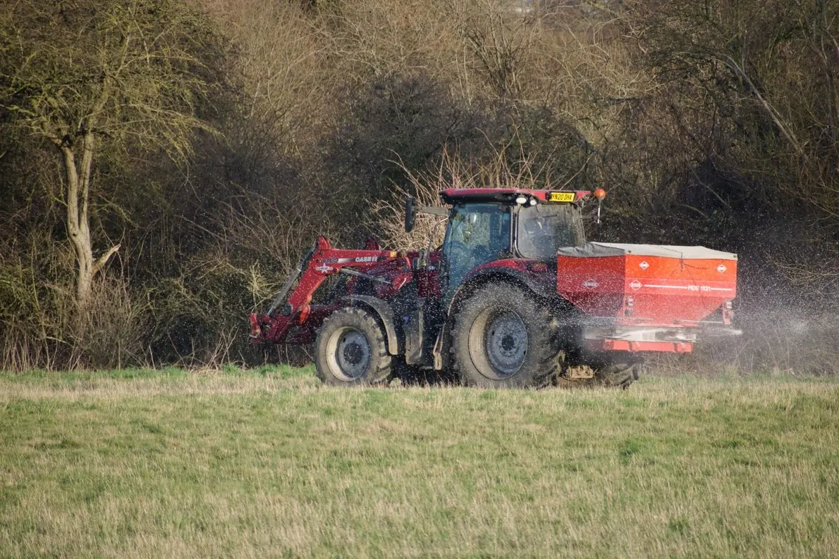 Red tractor with a fertilizer spreader