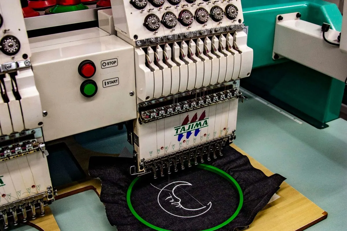 Multi-head industrial embroidery machine stitching a garment