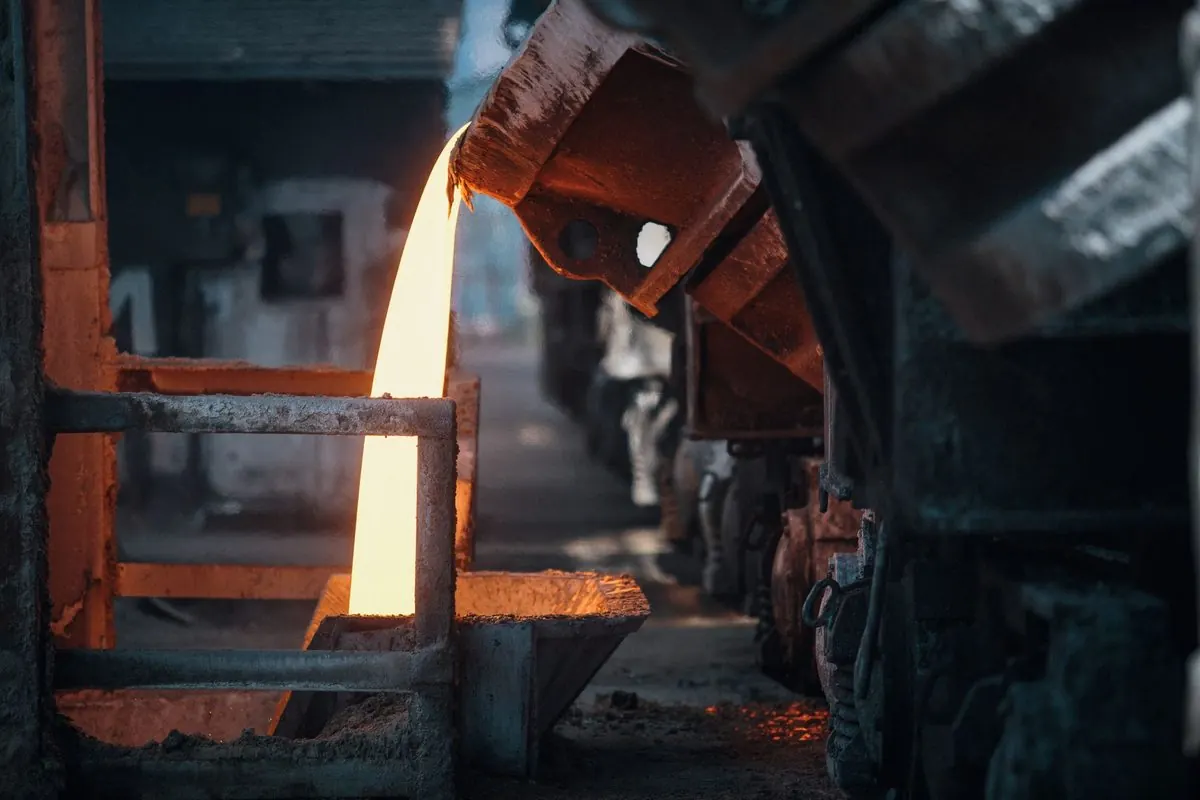 Molten steel poured from a ladle into a mould in a foundry