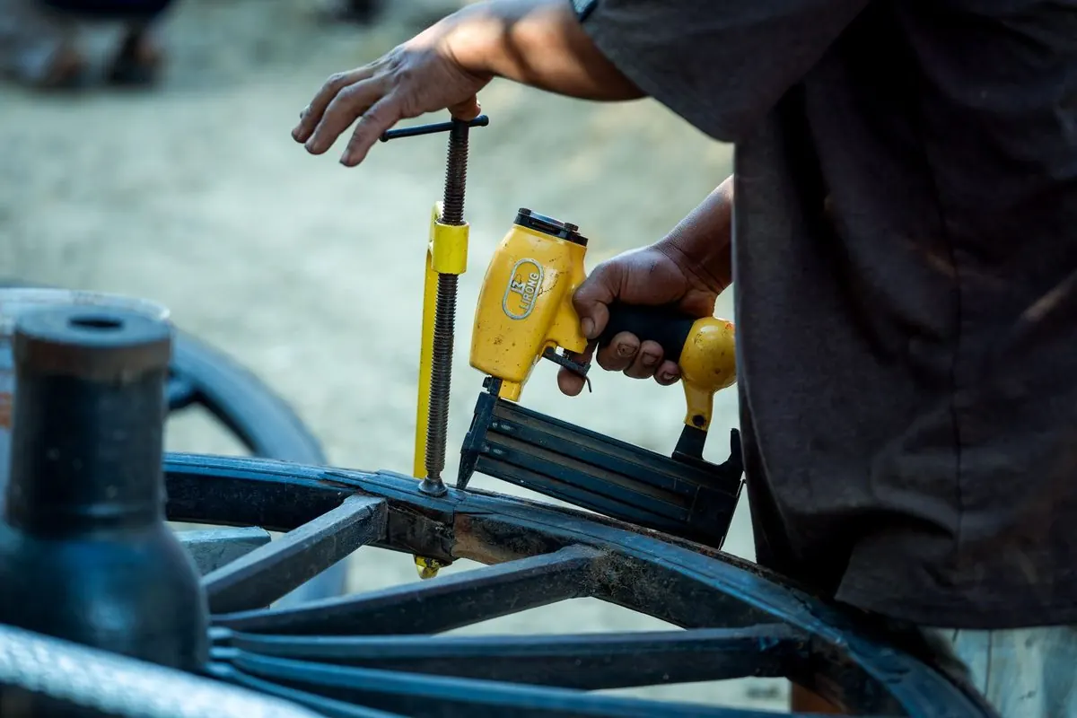 Worker using a yellow pneumatic nail gun