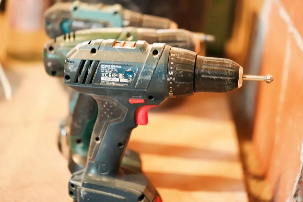 Row of cordless hand drills on a workbench