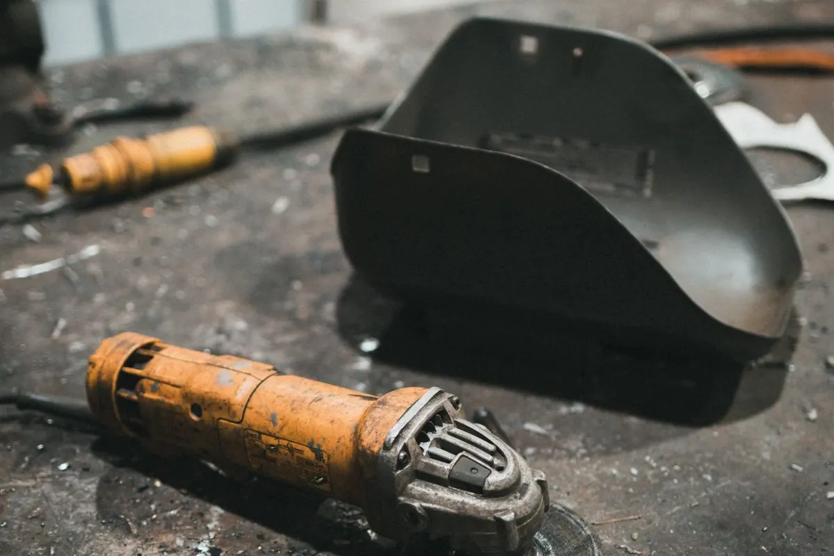 Orange handheld electric angle grinder on a workbench