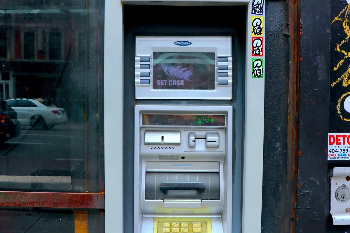 Wall-mounted silver ATM on a street