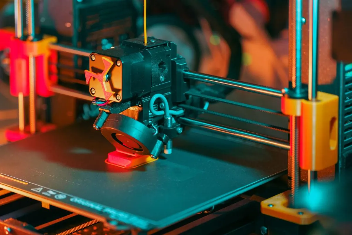 Plastic 3D printer at work with extruder and print bed visible