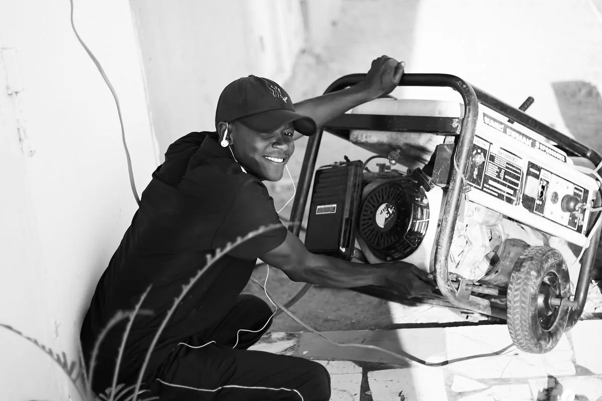Man carrying a portable petrol generator outdoors