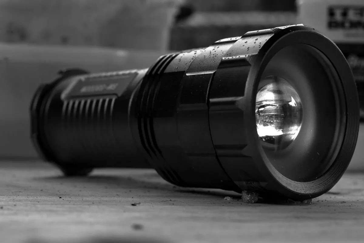 Black metal flashlight lying on a surface