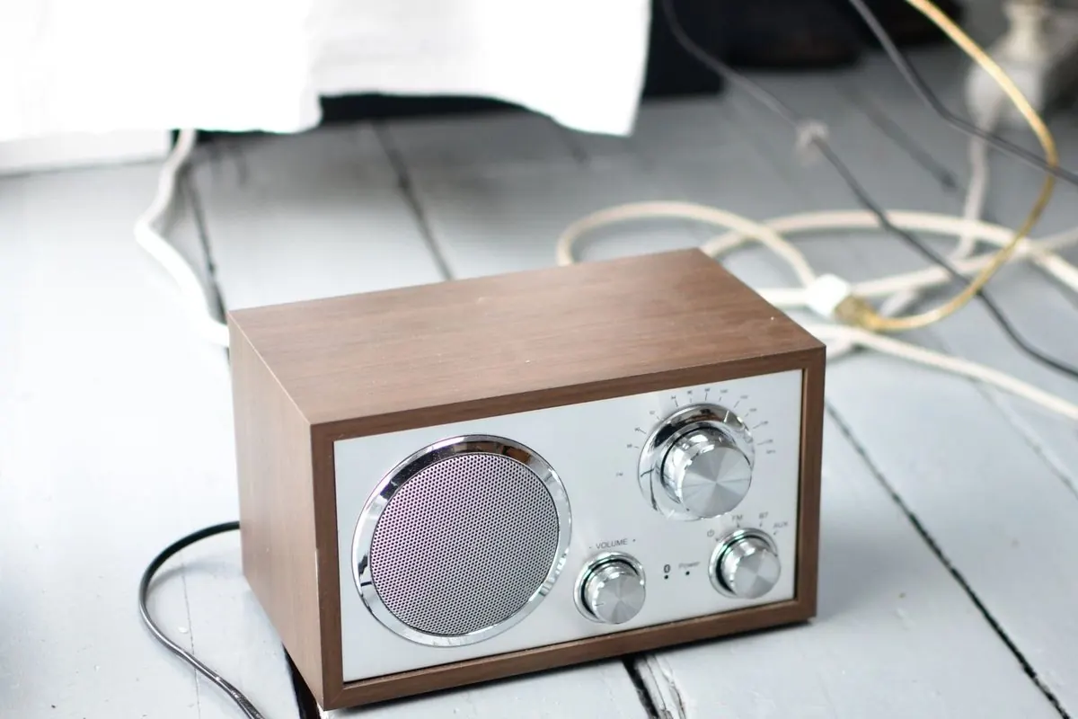Retro wooden-cased radio with a power cord on the floor