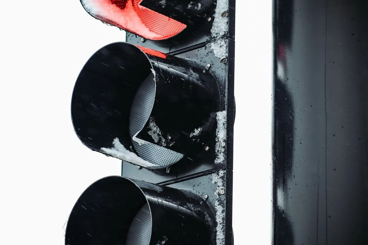 Black traffic light with the red lamp lit