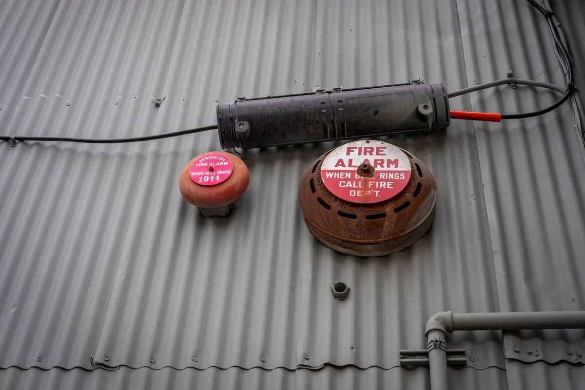 Old fire alarm bell mounted on a corrugated roof