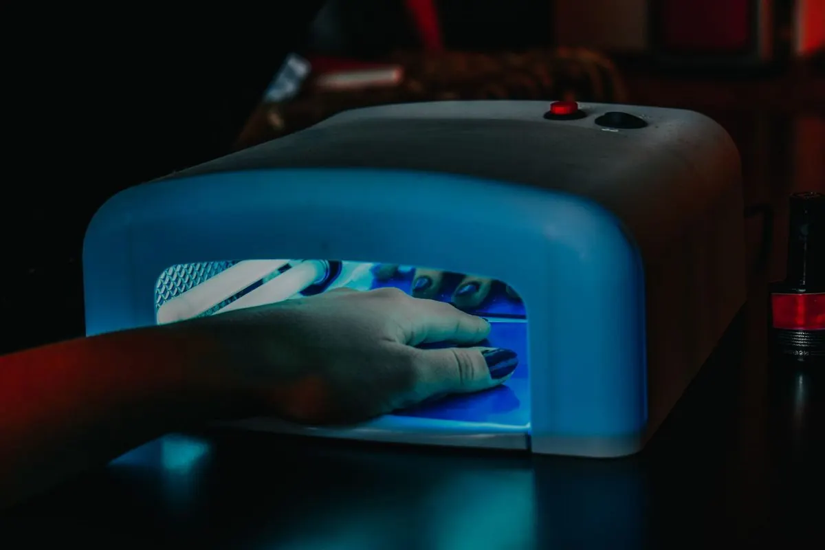 Hand placed inside a blue-lit ultraviolet lamp