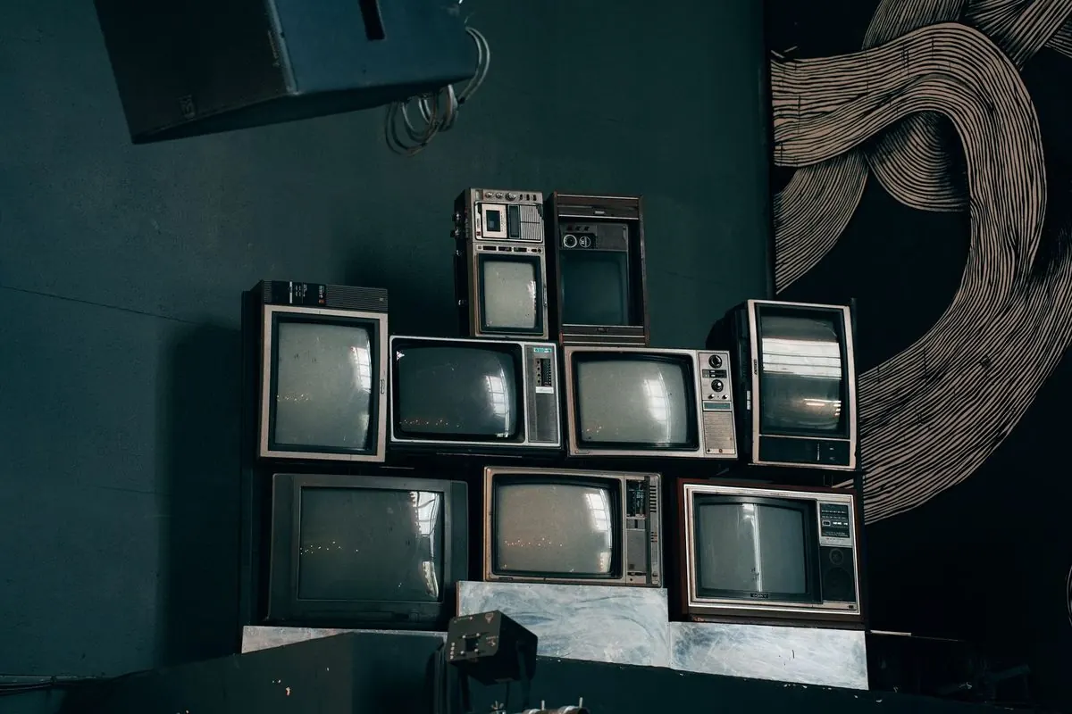 Stack of old CRT televisions in a dark room
