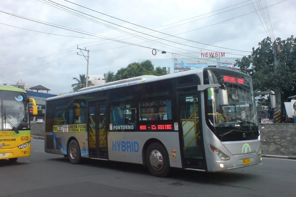 Xe buýt hybrid màu bạc chạy trên đường phố