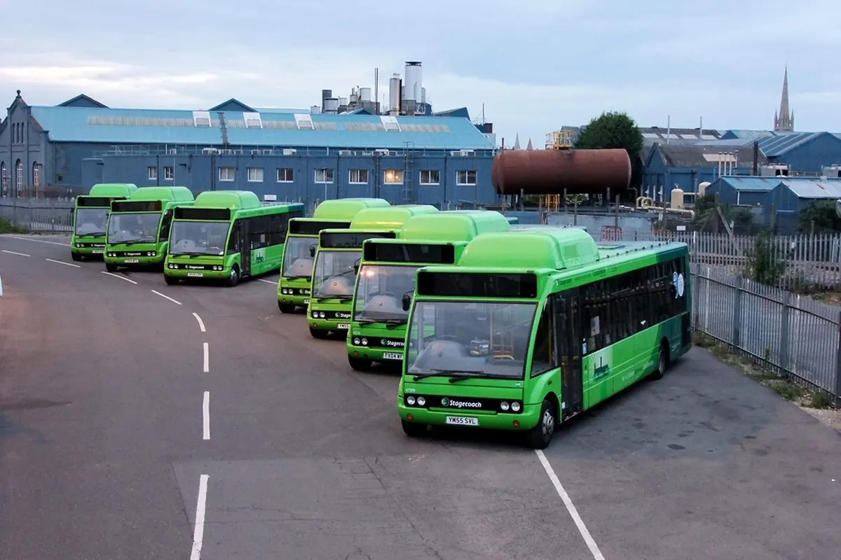 Dãy xe buýt hybrid màu xanh lá đỗ ở bãi xe
