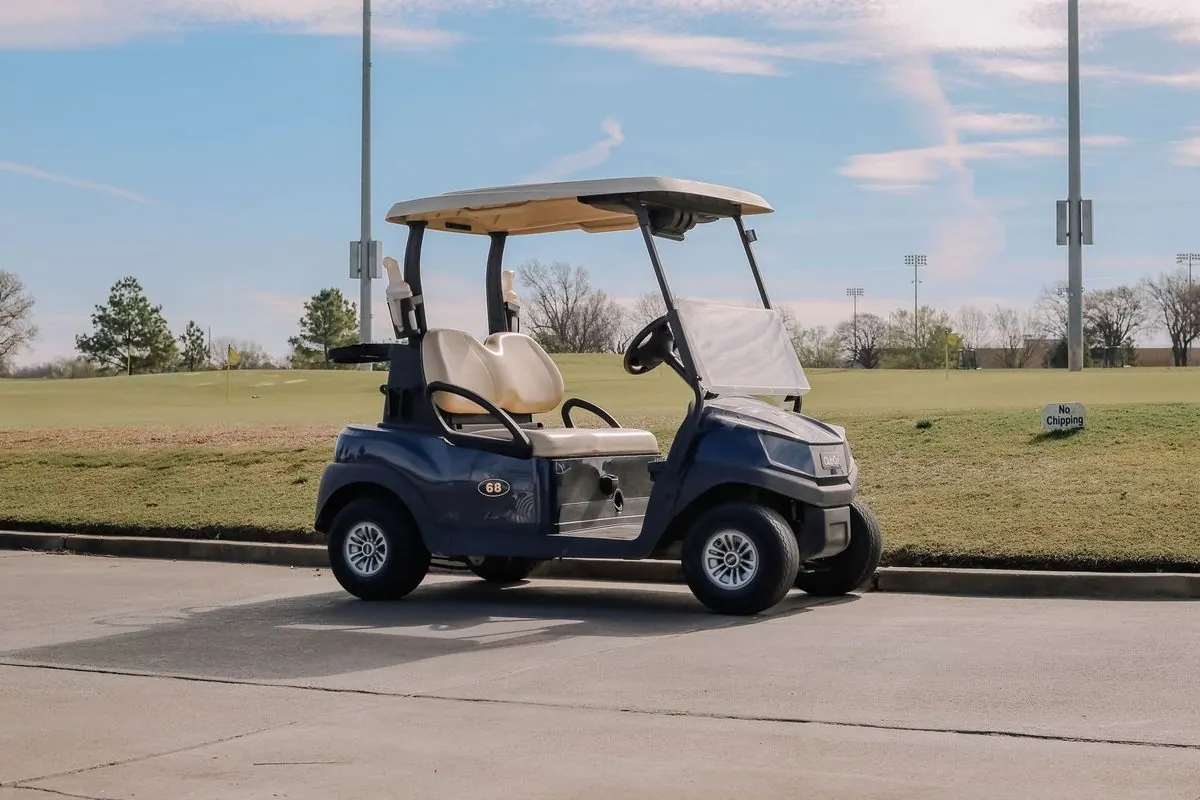 Dark blue electric golf cart parked on a course path