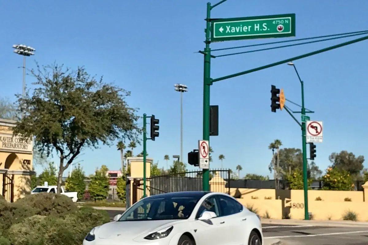 Xe điện Tesla trắng chạy trên đường phố
