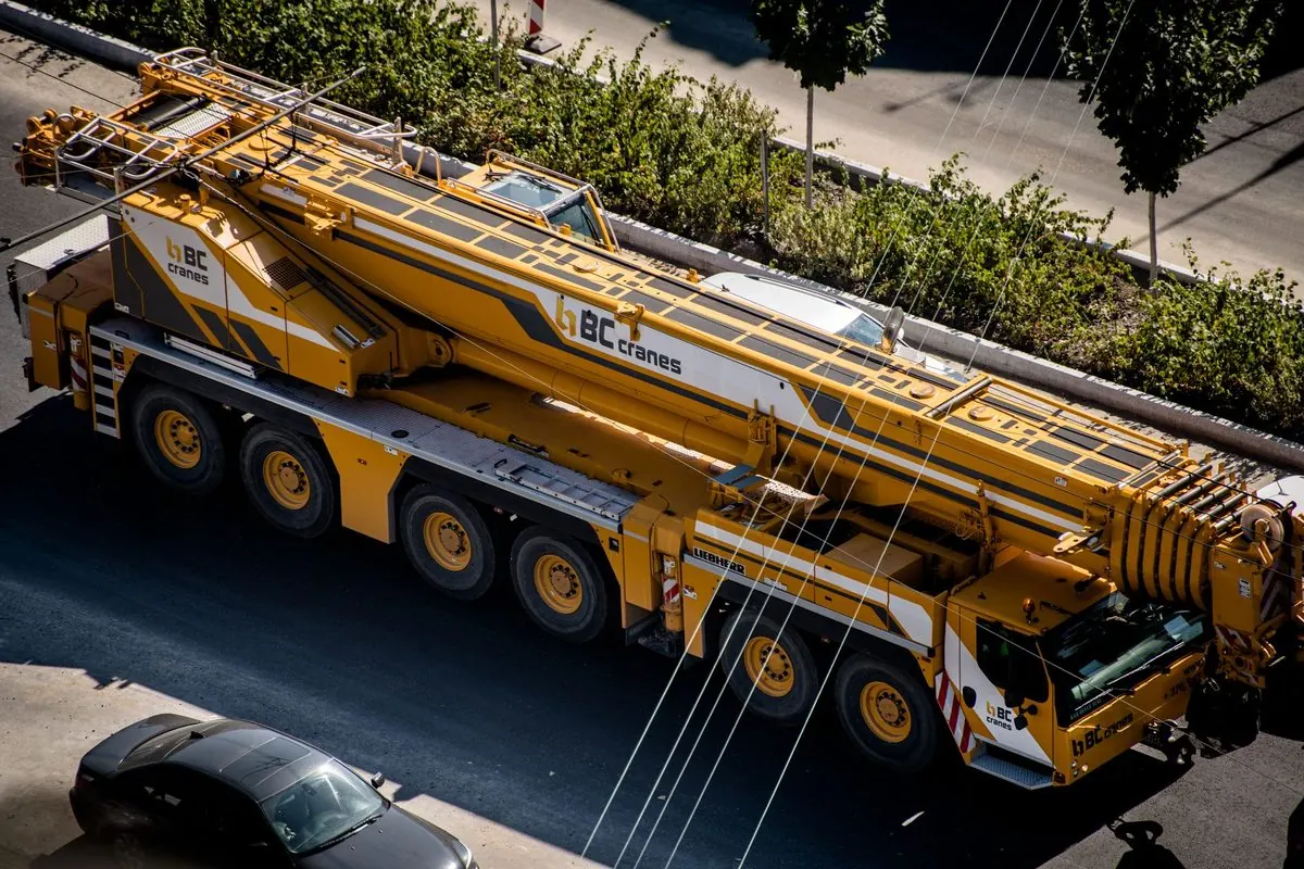 Xe cẩu bánh lốp màu vàng nhiều trục trên đường phố