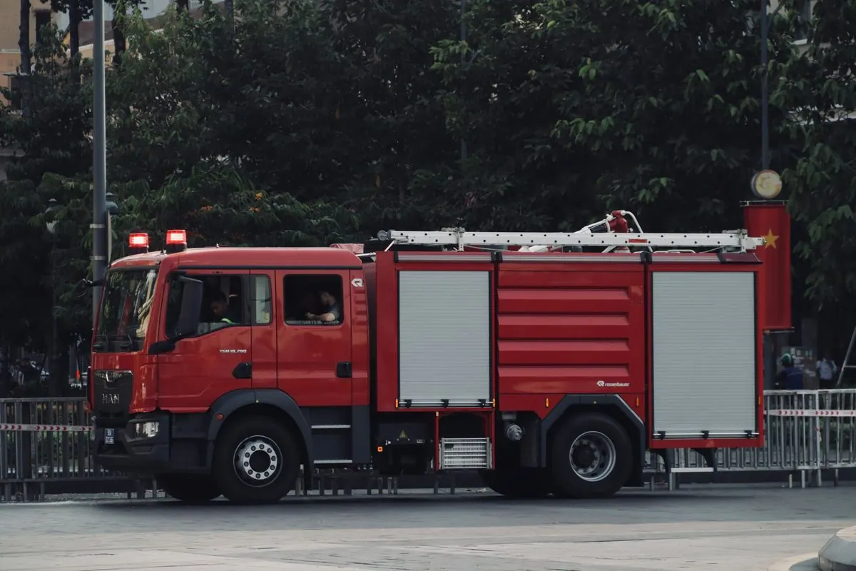 Xe chữa cháy màu đỏ có thang trên nóc đang đỗ ngoài phố