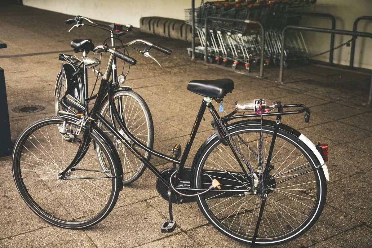 Black bicycle parked on a paved floor