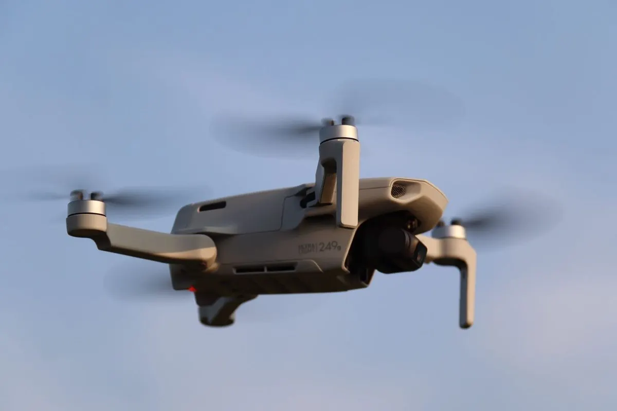 Compact flycam in flight against a blue sky