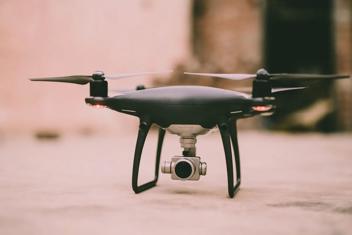 Drone bốn cánh quạt màu đen có camera đặt trên mặt đất