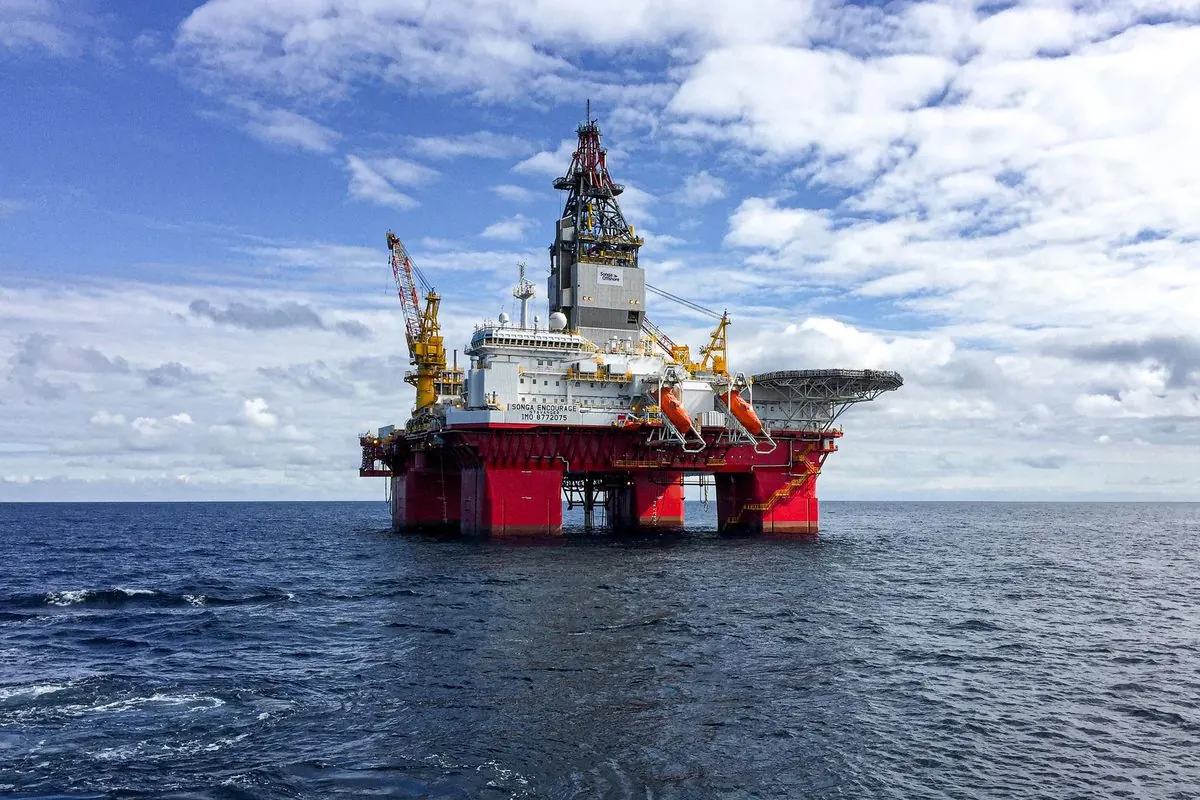 Red semi-submersible oil drilling rig in open sea