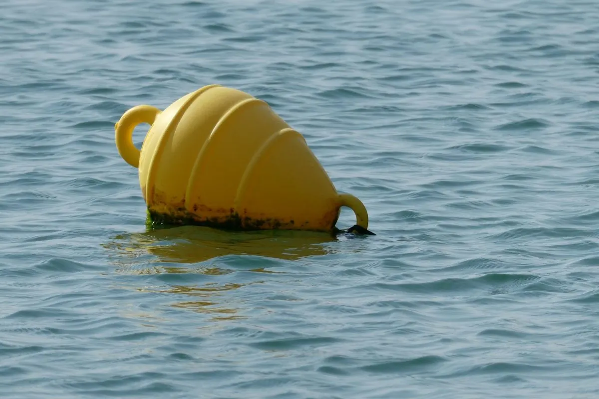 Yellow mooring buoy floating on the sea