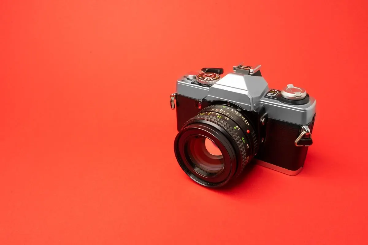 Vintage 35 mm film camera on an orange background