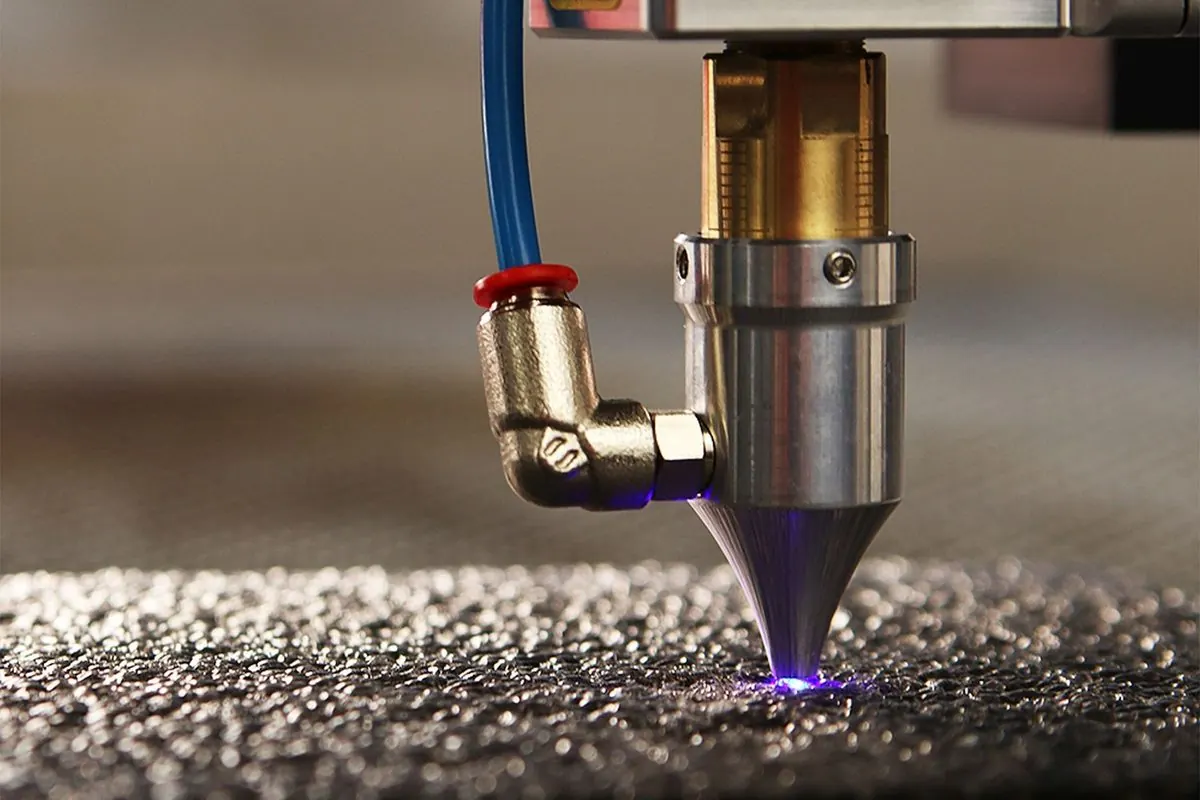 Đầu laser công nghiệp đang cắt bề mặt vật liệu