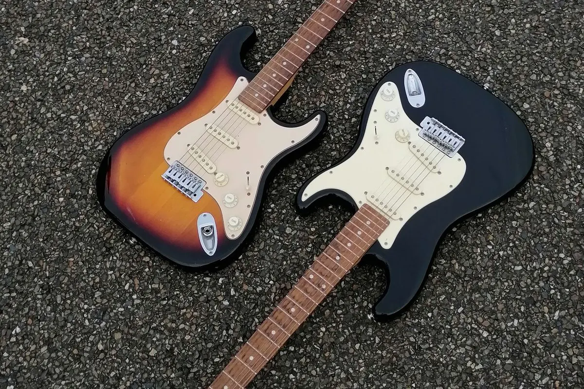 Hai cây đàn guitar điện đặt trên nền bê tông