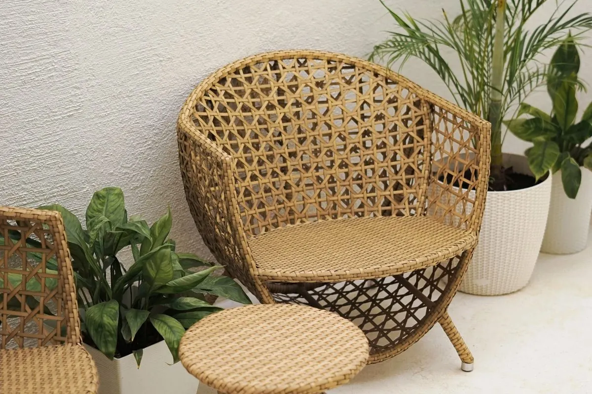 Ghế và bàn nhỏ đan mây cạnh cây xanh