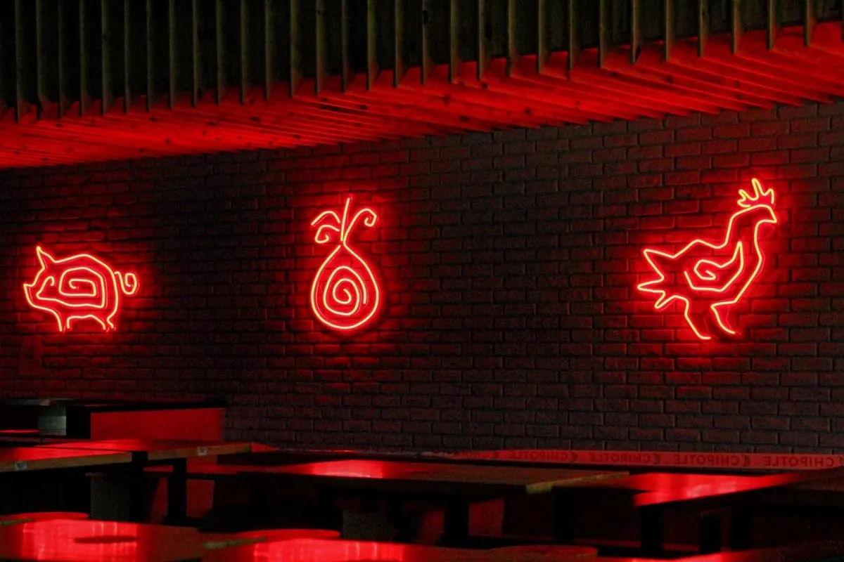 Ba biển đèn neon đỏ hình con vật trên tường gạch