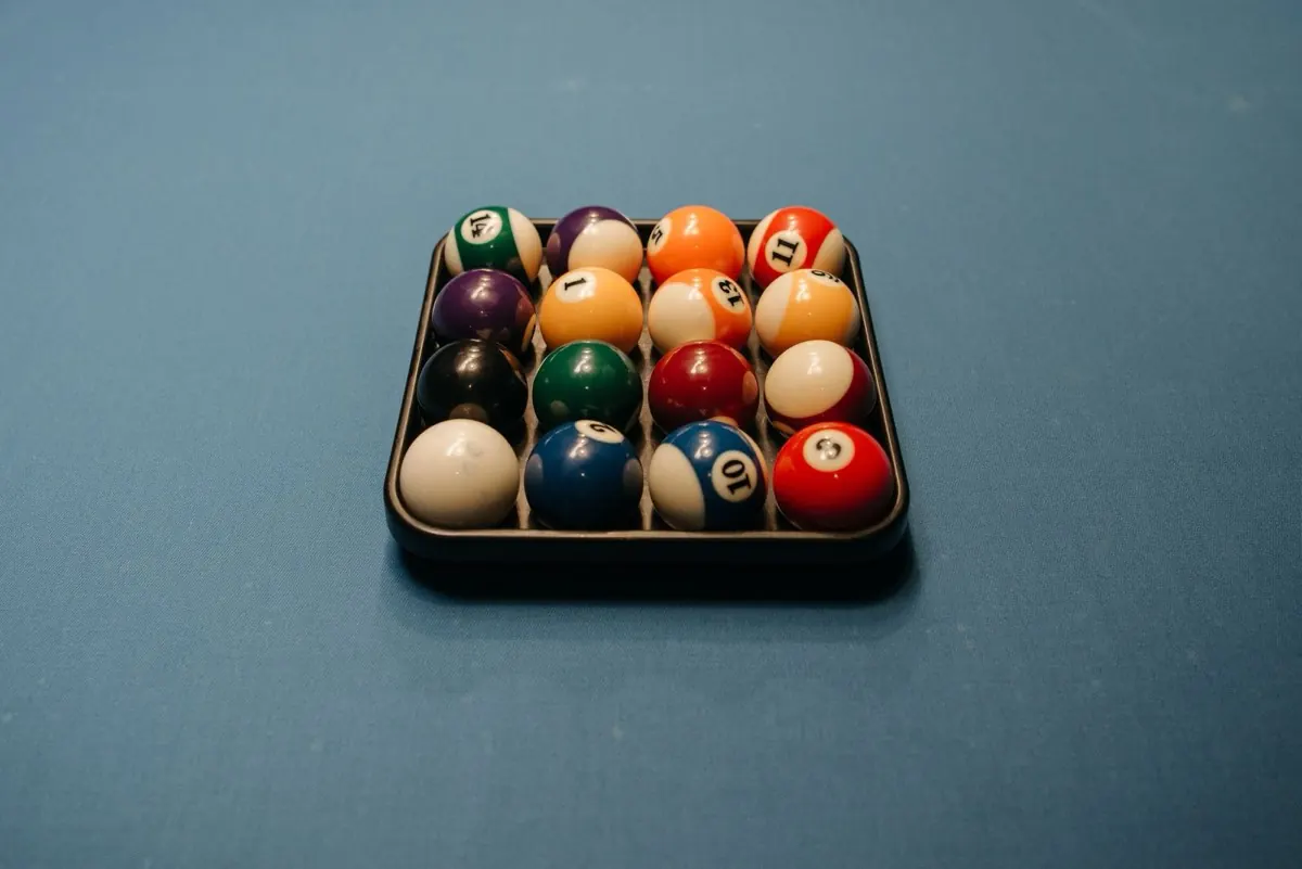 Bộ bi a xếp trong khay trên bàn nỉ xanh