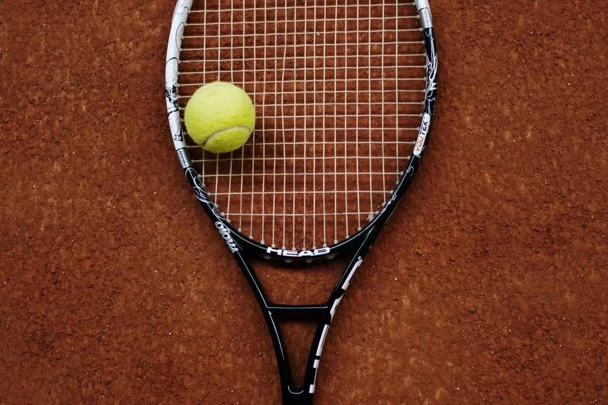 Vợt tennis và quả bóng trên sân đất nện